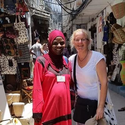 An English language course volunteer in Tanzania practices her new skills on a local market. A Projects Abroad volunteer meets up with local woman during her English language course in Tanzania